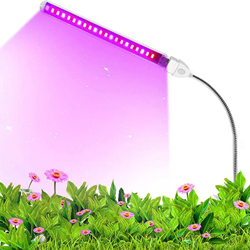 Portable AITHEA LED grow light bar with a flexible neck emitting a bright pink-purple spectrum over green potted plants.